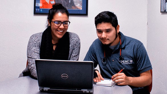Program advisor sitting at a table with a student.
